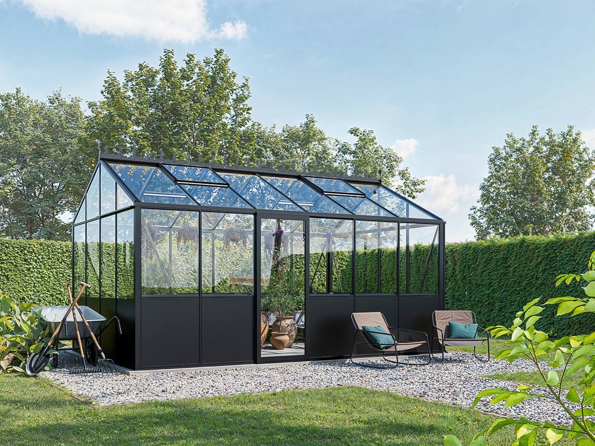Elegant fristående växthus som integrerad del av trädgårdens arkitektur