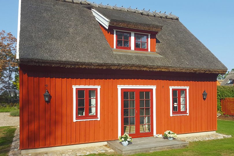 En liten träbyggnad med matchande fönster och dörrar till en låg kostnad