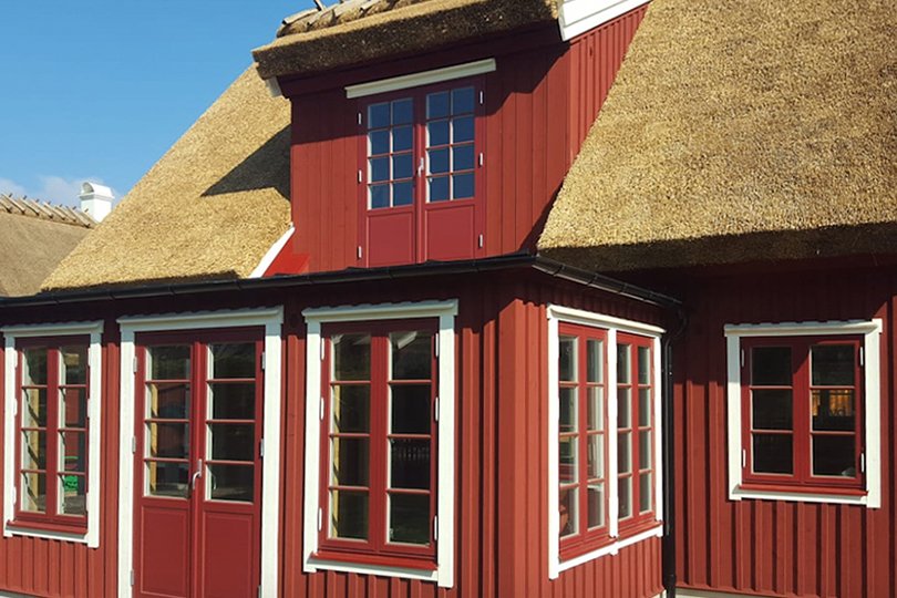 Klassiskt trähus med röda fönster