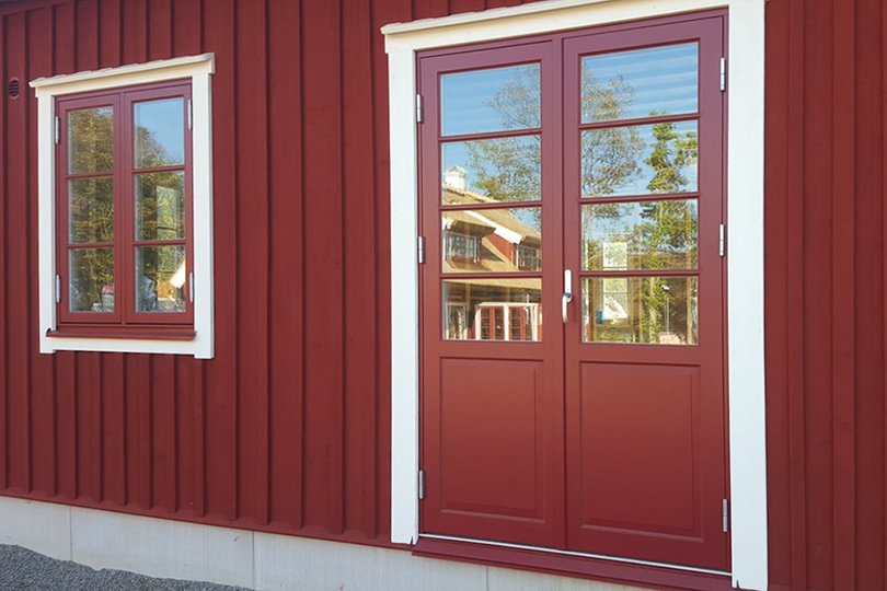 Röda dubbeldörrar med matchande fönster